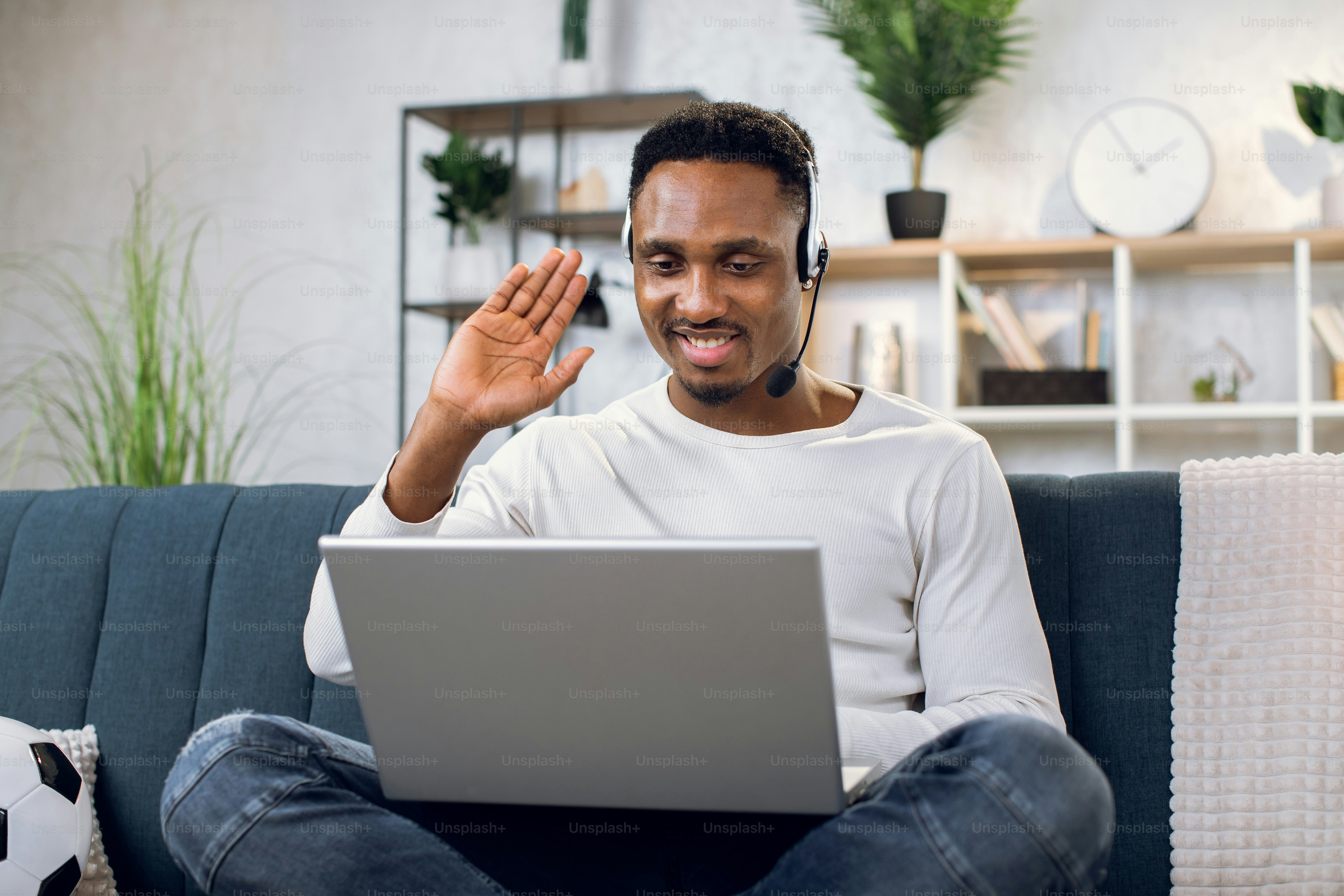 Portrait of handsome african guy in headset using wireless laptop for ...
