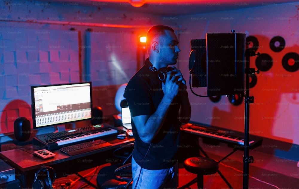 보컬리스트는 현대적인 전문 스튜디오에서 실내에서 녹음 세션을 갖습니다.