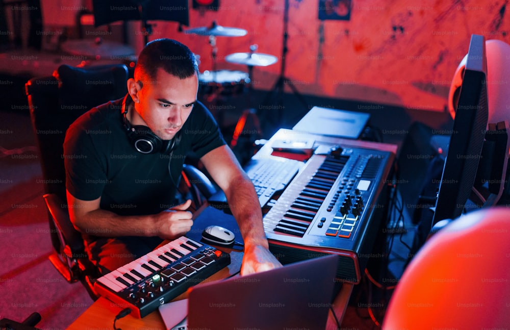 Ingeniero de sonido profesional trabajando y mezclando música en el interior del estudio.
