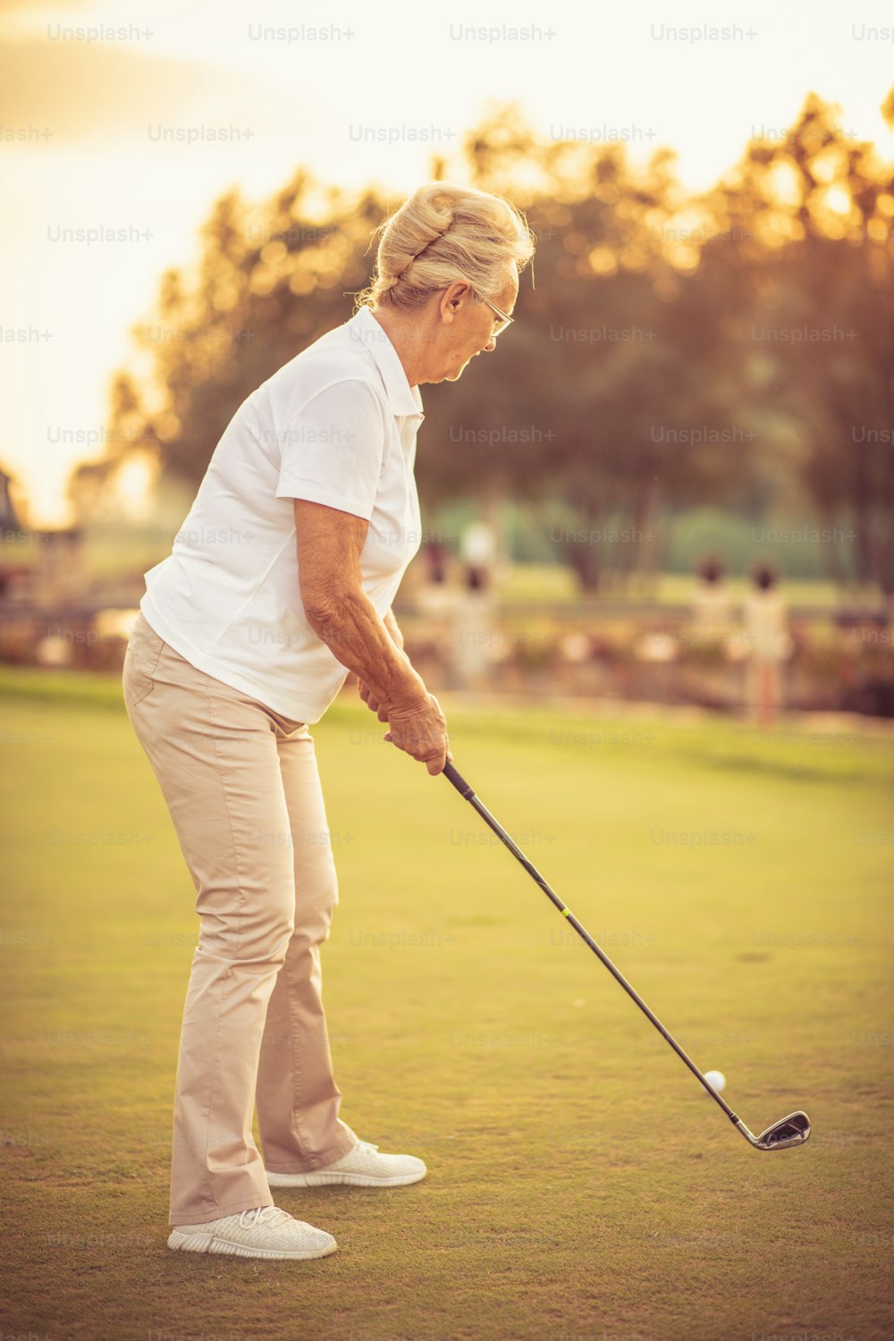 Senior woman playing the golf. Close up.