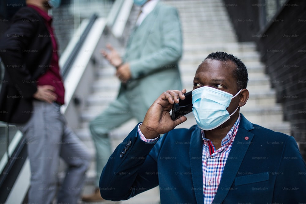 Small Group of business men with protective mask on face. Using mobile.
