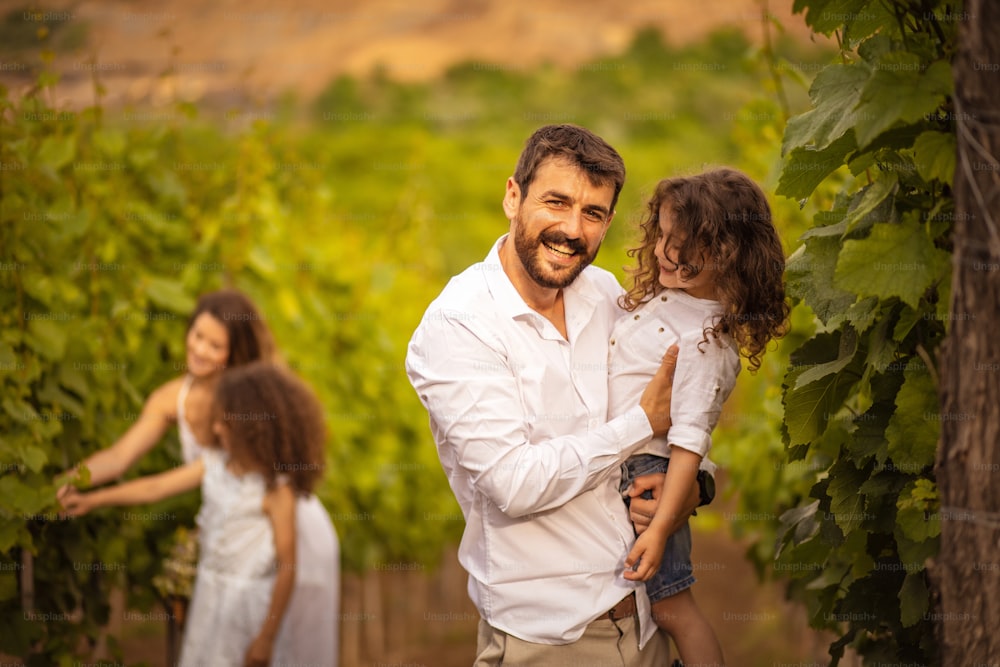 Young family in vineyard. Focus is on foreground.