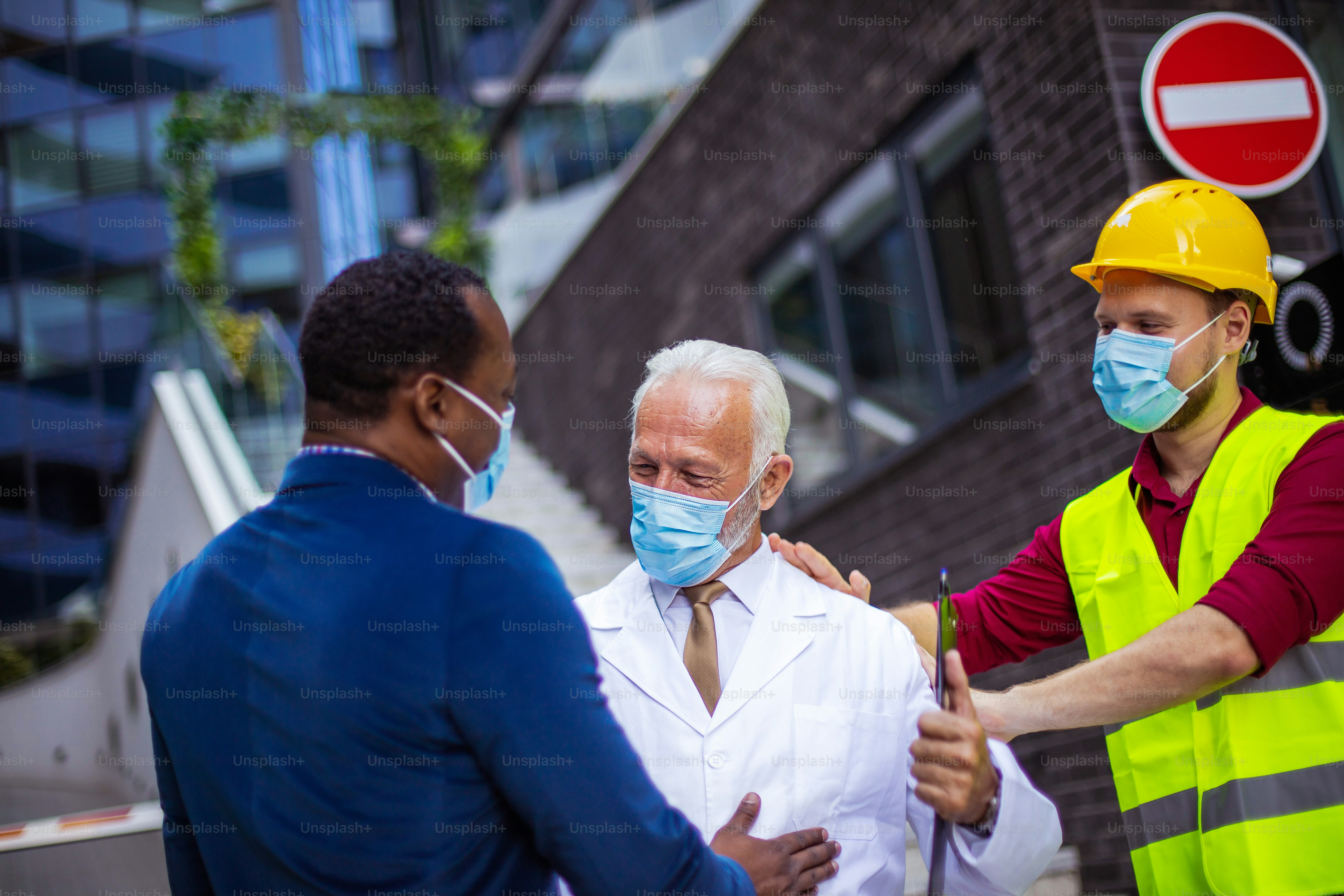 Business man, doctor and engineer talking on street.