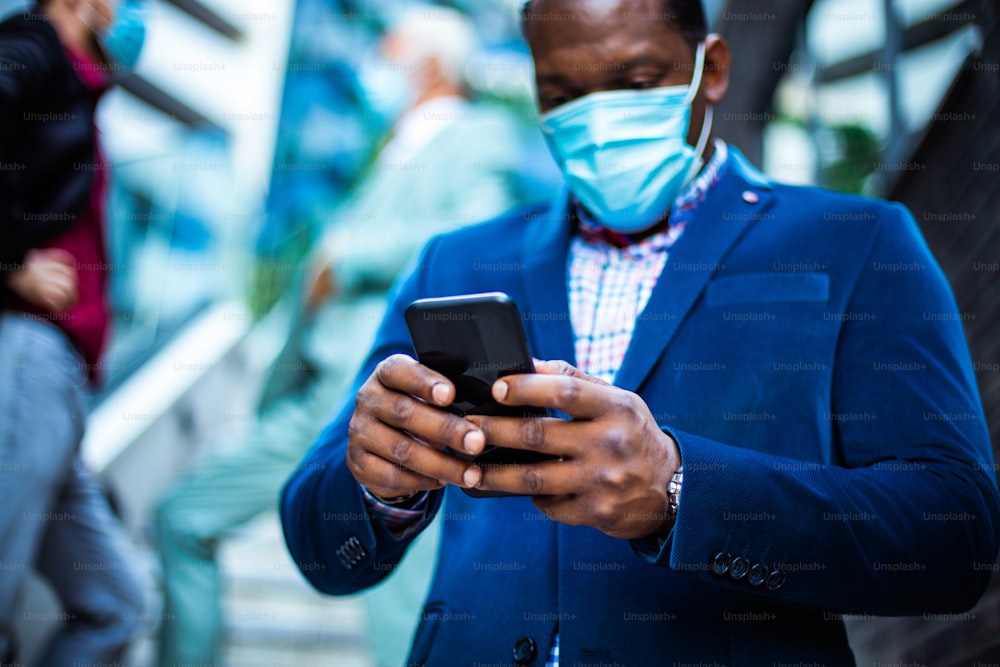 Small Group of business men with protective mask on face. Using mobile.
