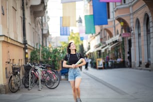 This city is beautiful.  Woman on street with map in hands.