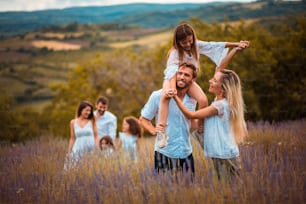 Large group of people in lavender field. Focus is on foreground.