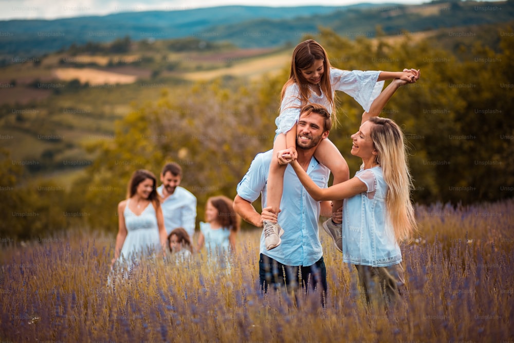 Grand groupe de personnes dans un champ de lavande. La mise au point se fait sur le premier plan.