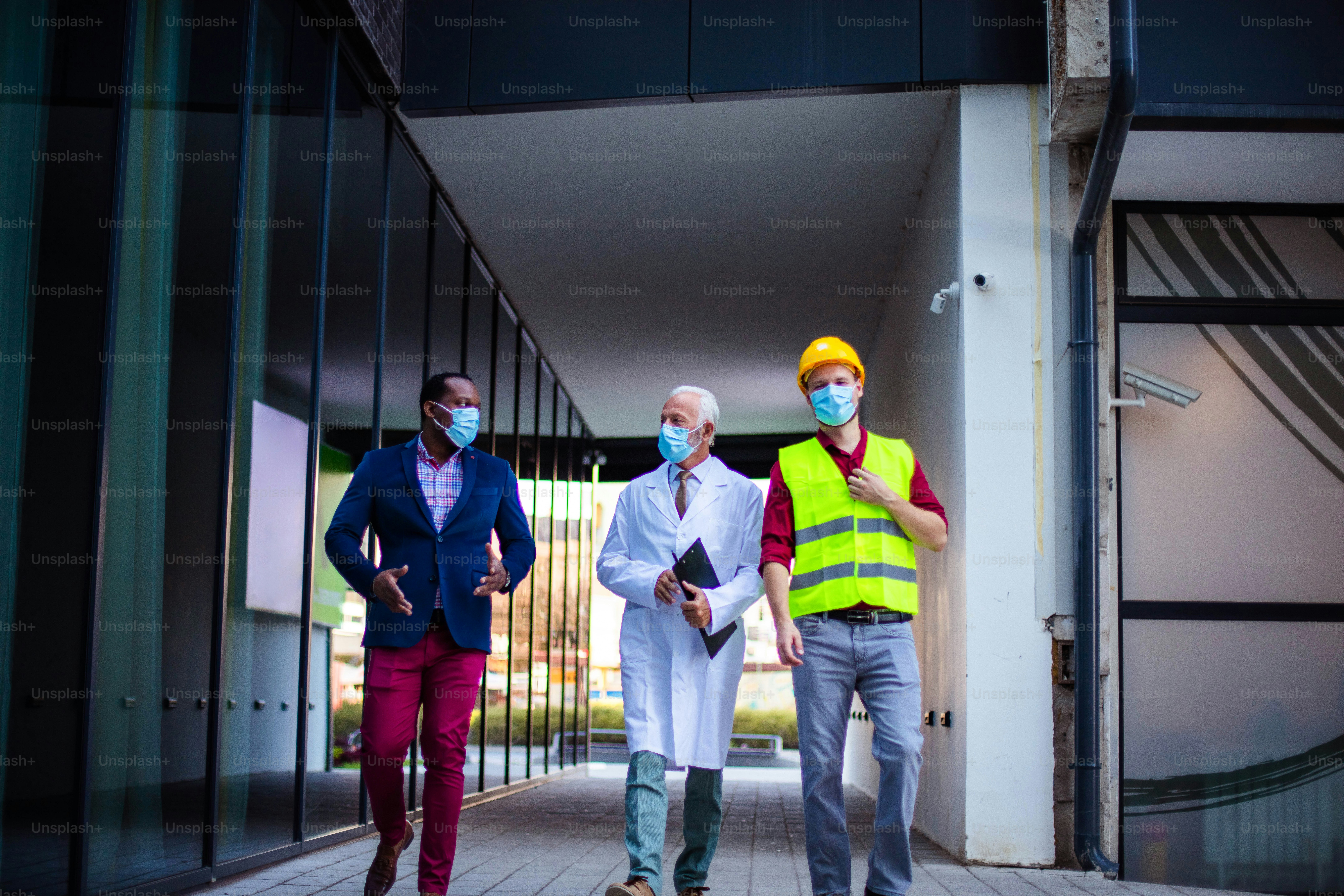 Business man, doctor and engineer walking trough street.