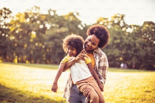 Mère afro-américaine et fille courant dans le parc. Concentrez-vous sur la petite fille.