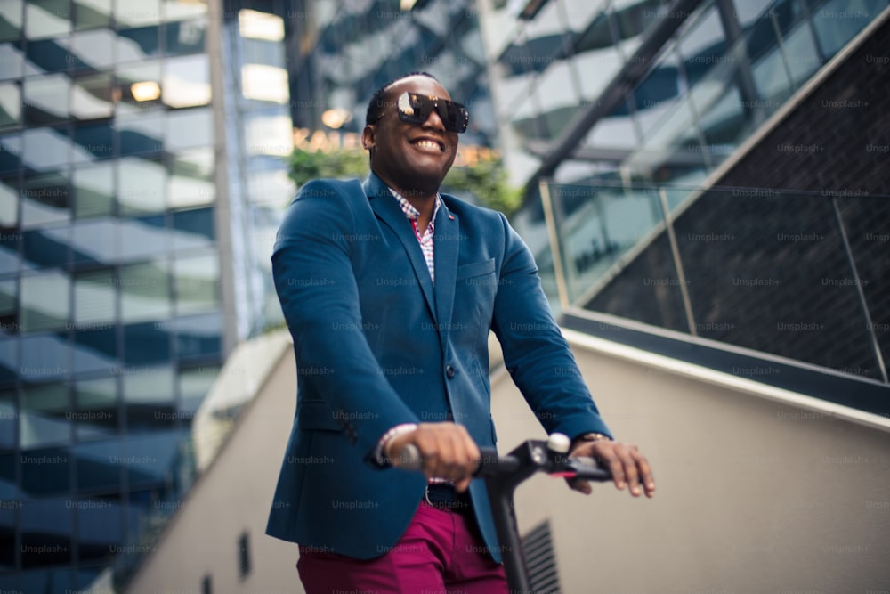 Homem de negócios andando de scooter elétrico na cidade.