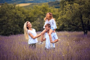 Porträt einer lächelnden Familie im Lavendelfeld.