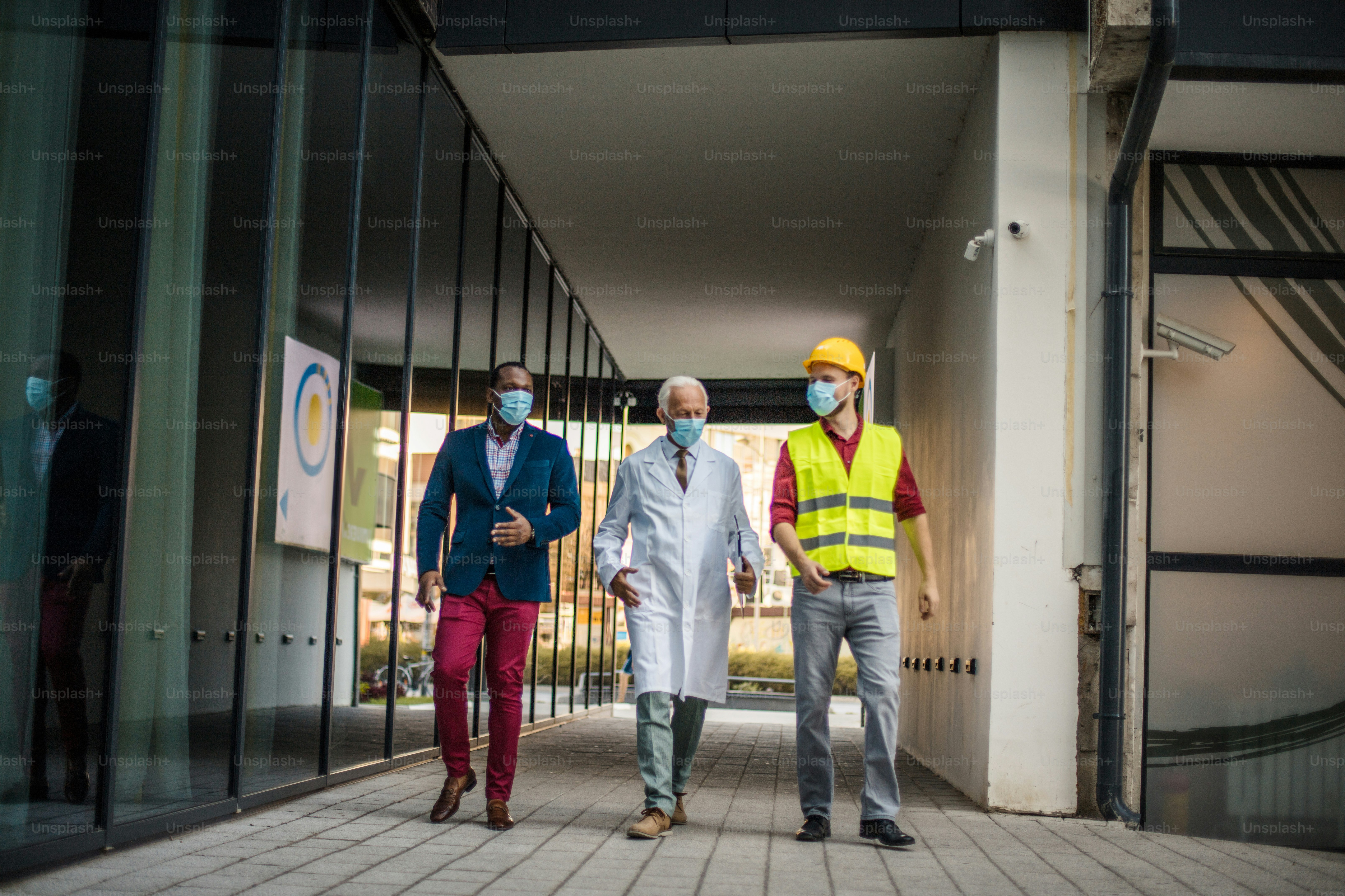 Business man, doctor and engineer walking trough street.