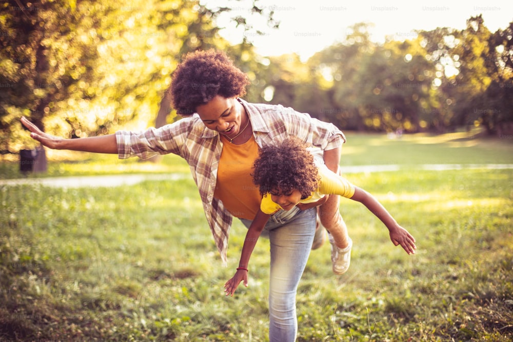 Afroamerikanische Mutter und Tochter spielen im Park.