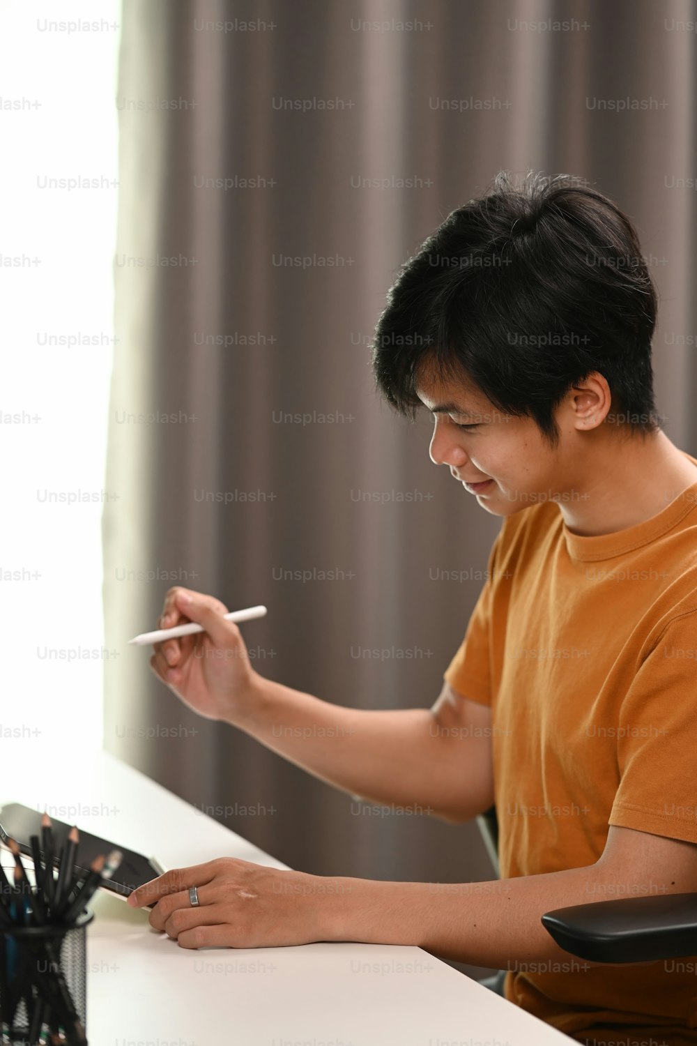 Retrato do homem feliz segurando caneta stylus e trabalhando com tablet digital.