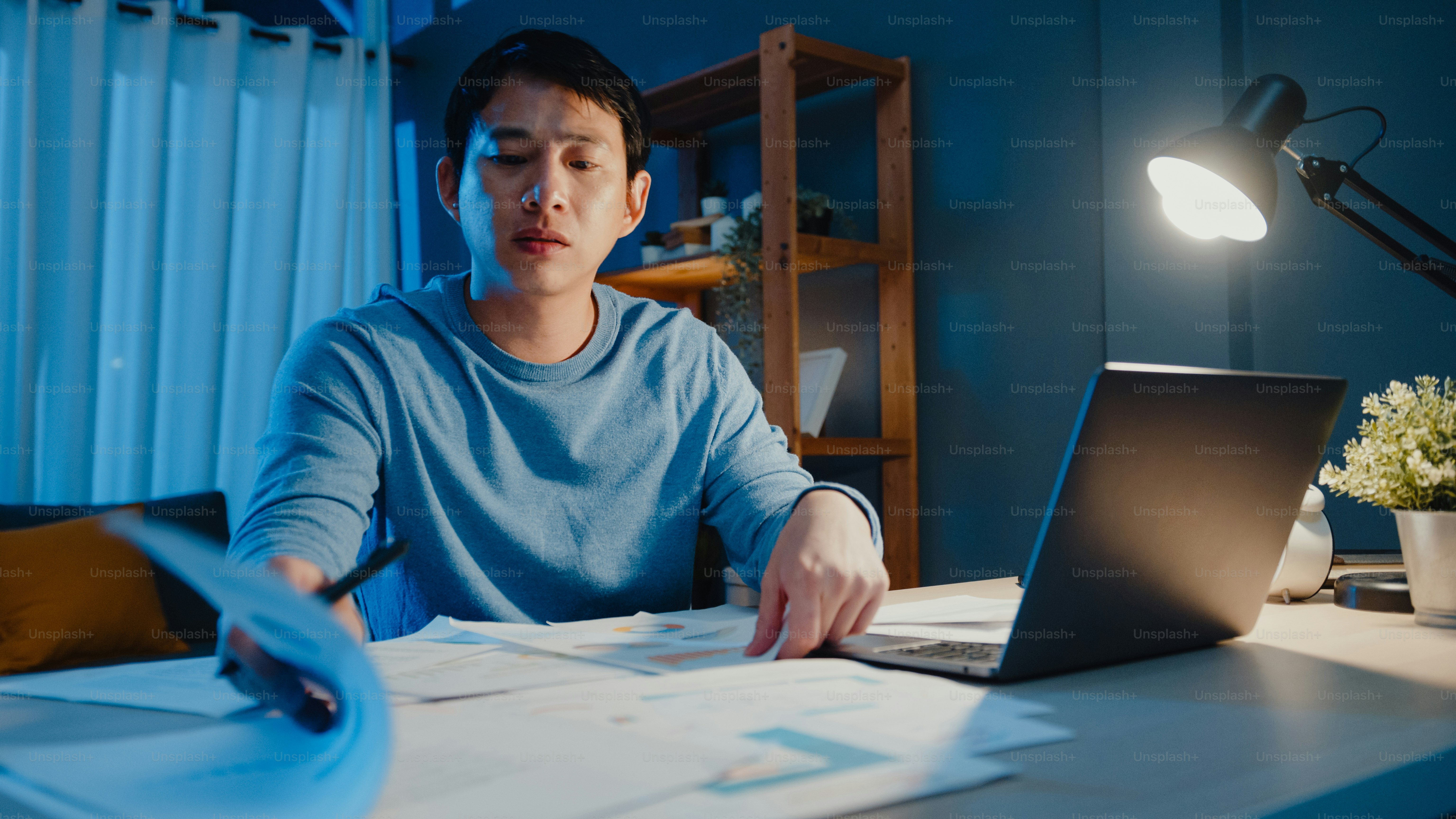 Man reading documents in blue sweater - Photo on Unsplash+