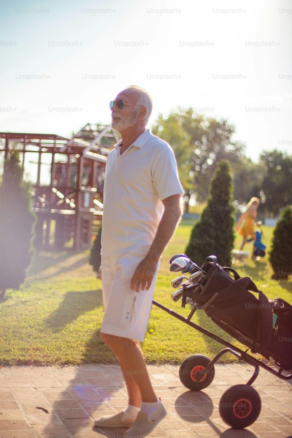 Senior man walking with golf bag.