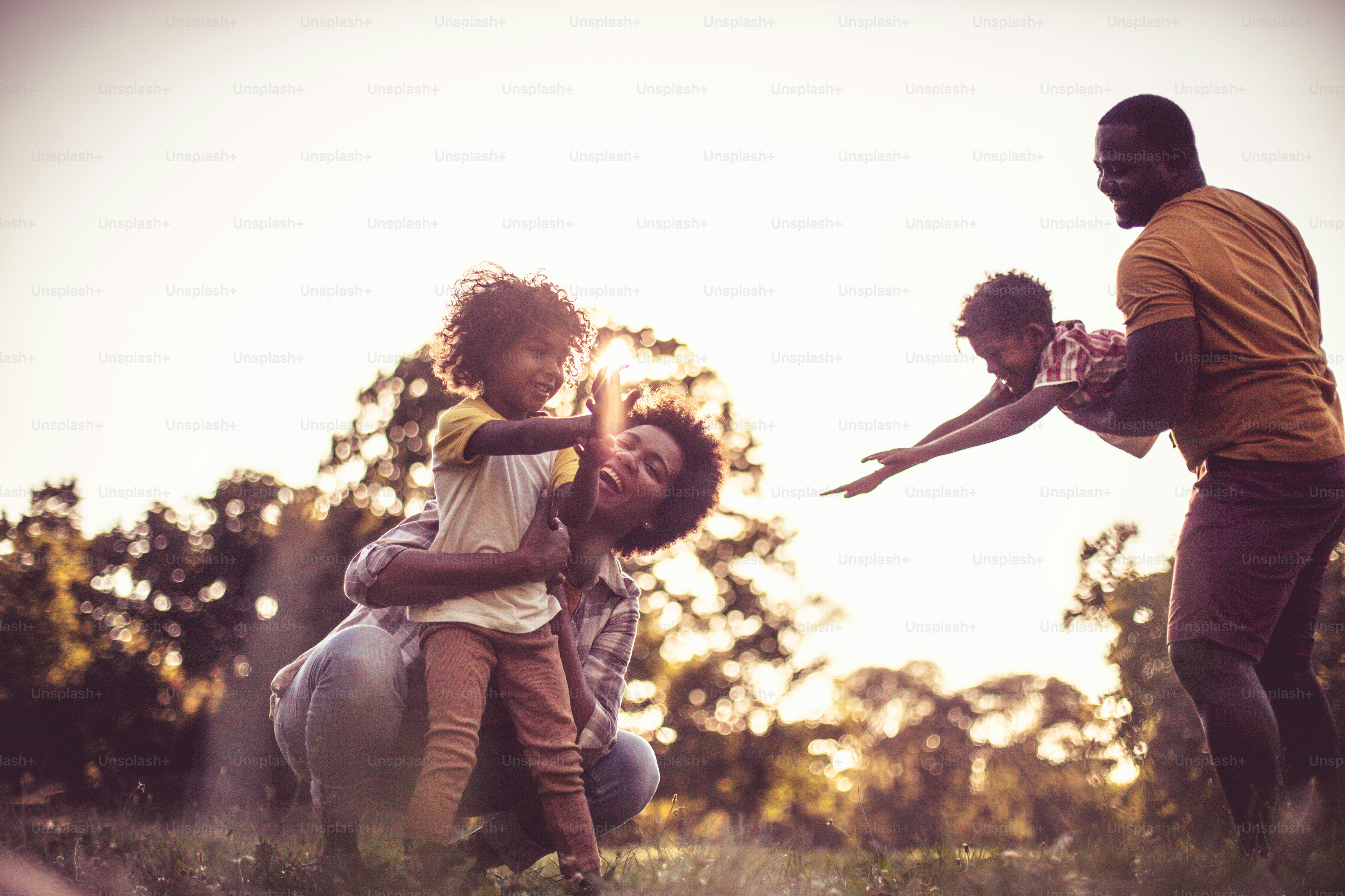 Familia africana feliz jugando en la naturaleza.