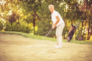 Senior woman playing golf.