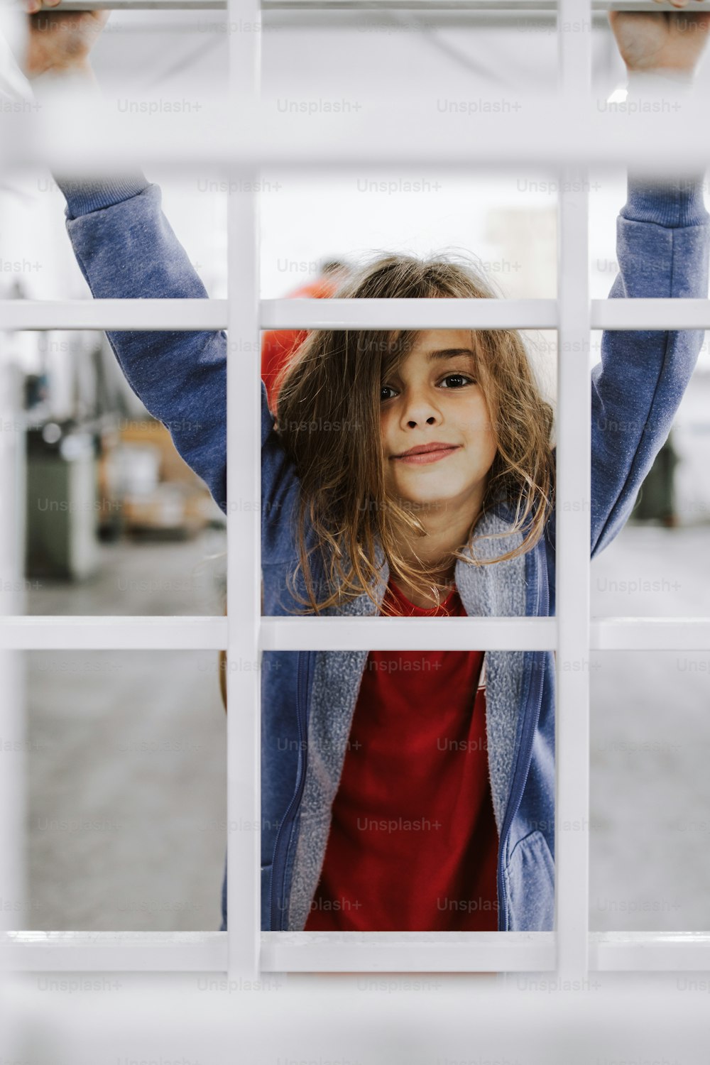 Beautiful young girl is playing in manufacturing facility while her father working there.