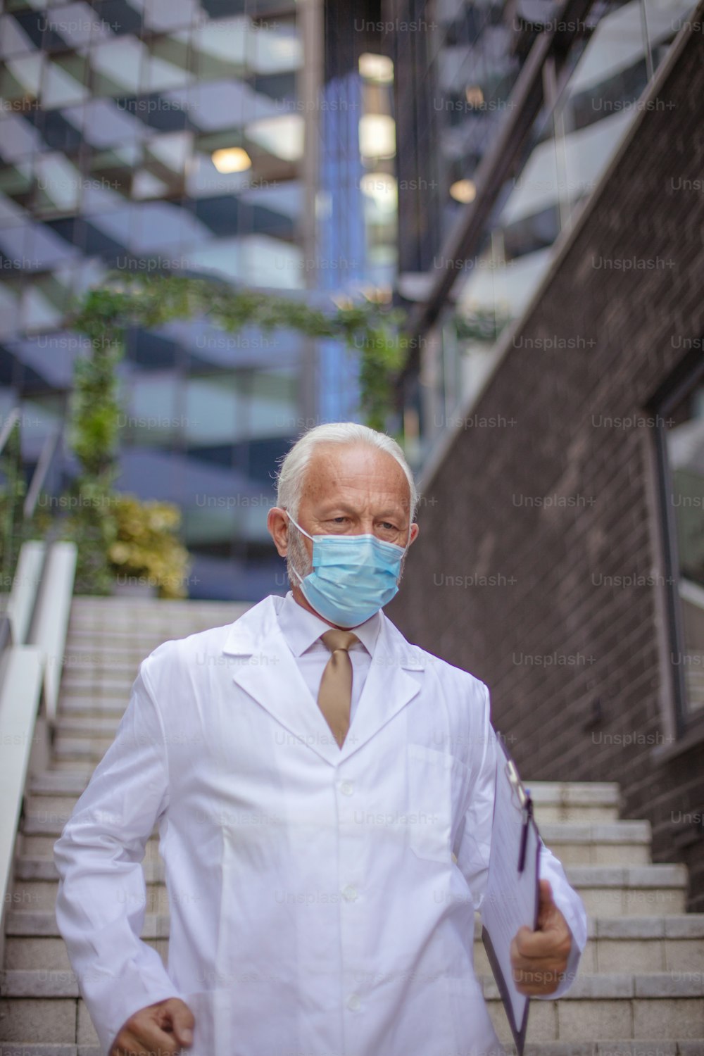 Mature doctor on street with protective mask.