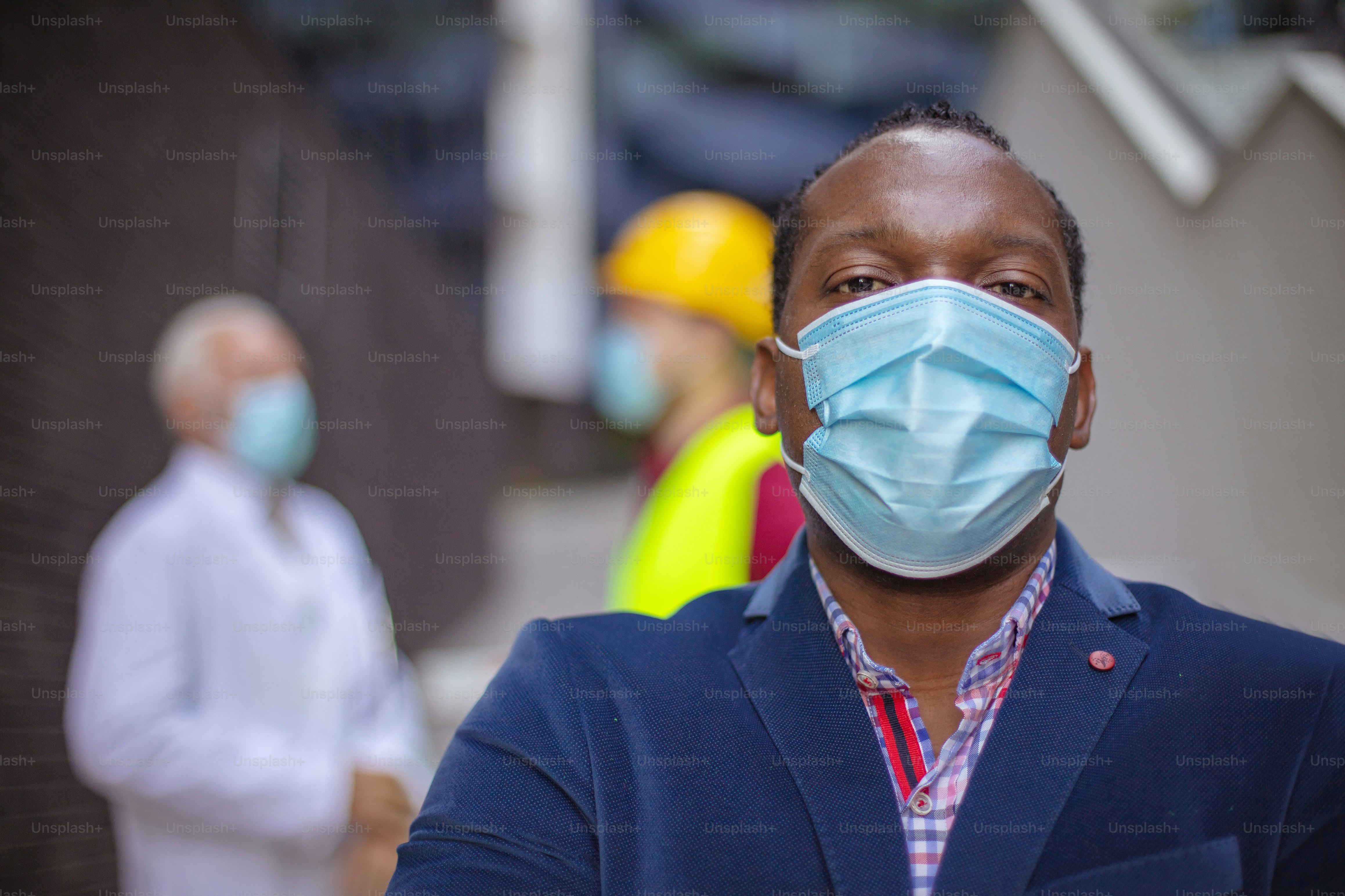 Homem de negócios, médico e engenheiro na rua. O foco está no homem.