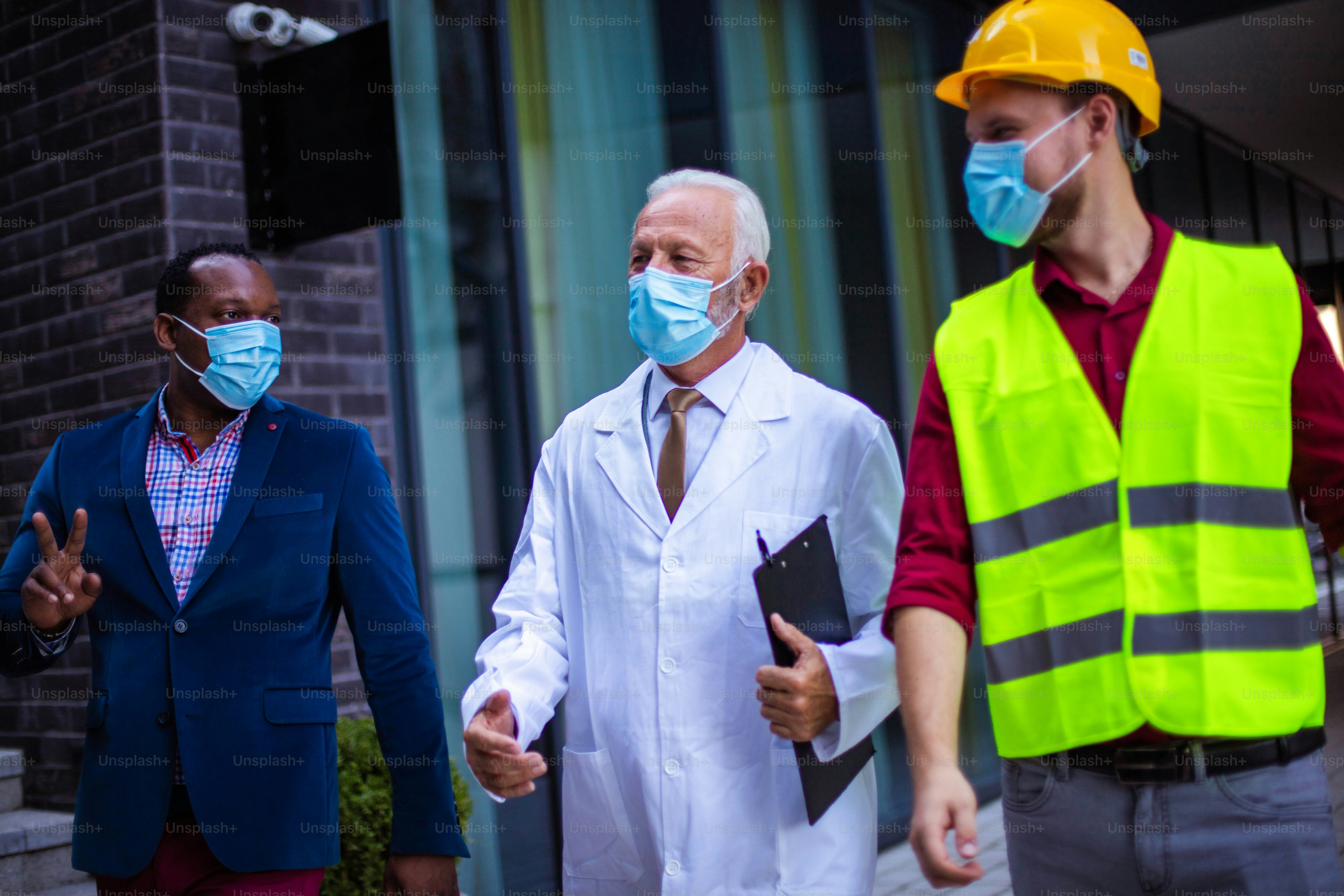 Business man, doctor and engineer talking on street.
