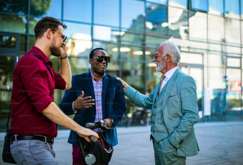 Pequeno grupo de homens de negócios falando na rua. Concentre-se no homem negro.