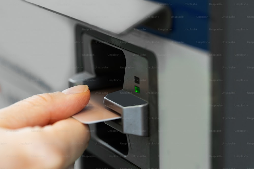 Close up da mão feminina com um cartão de crédito e máquina de venda automática de bilhetes