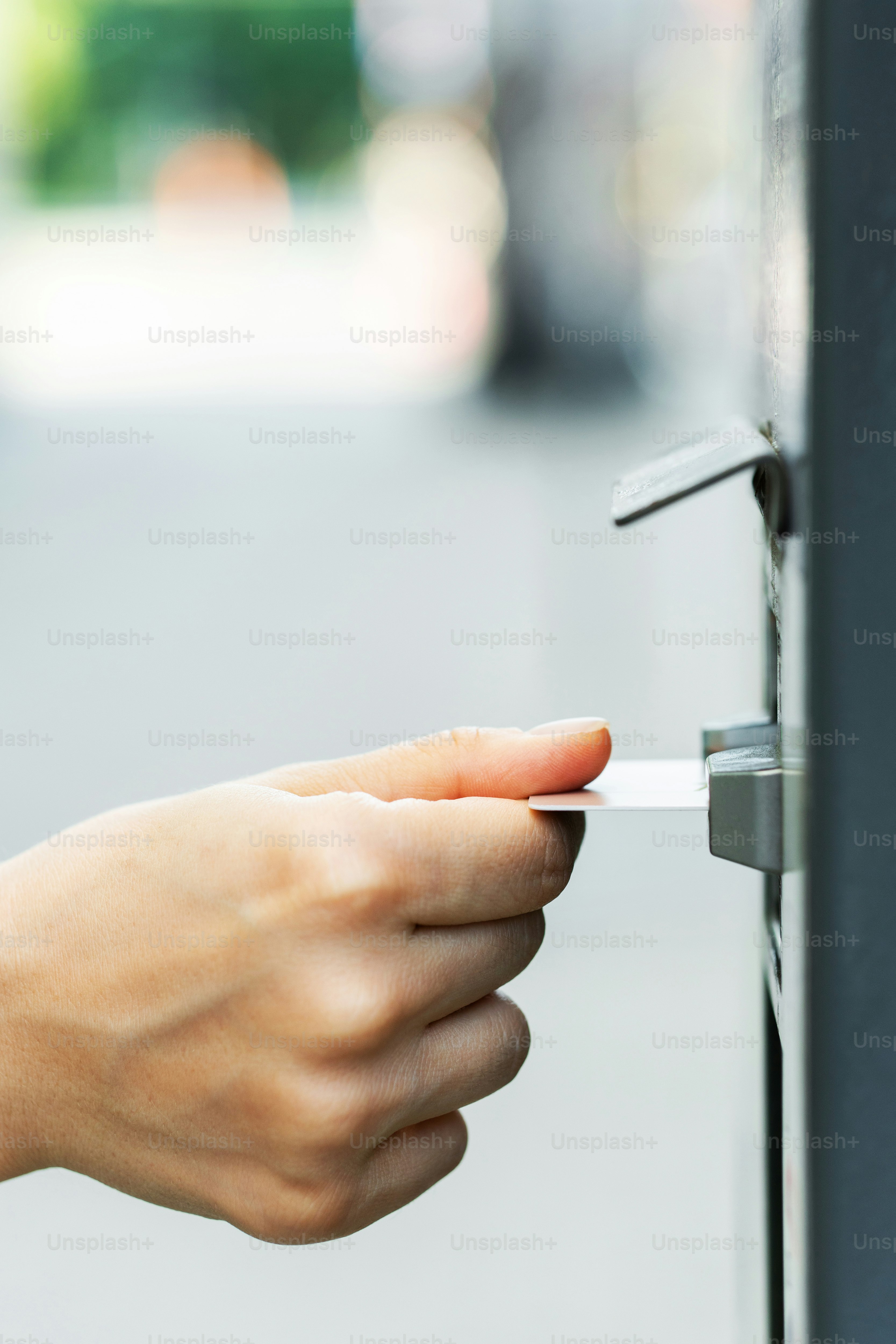 Closeup of female hand with a credit card and ticket vending machine