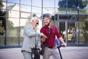 Two business men riding electric scooter in the city.