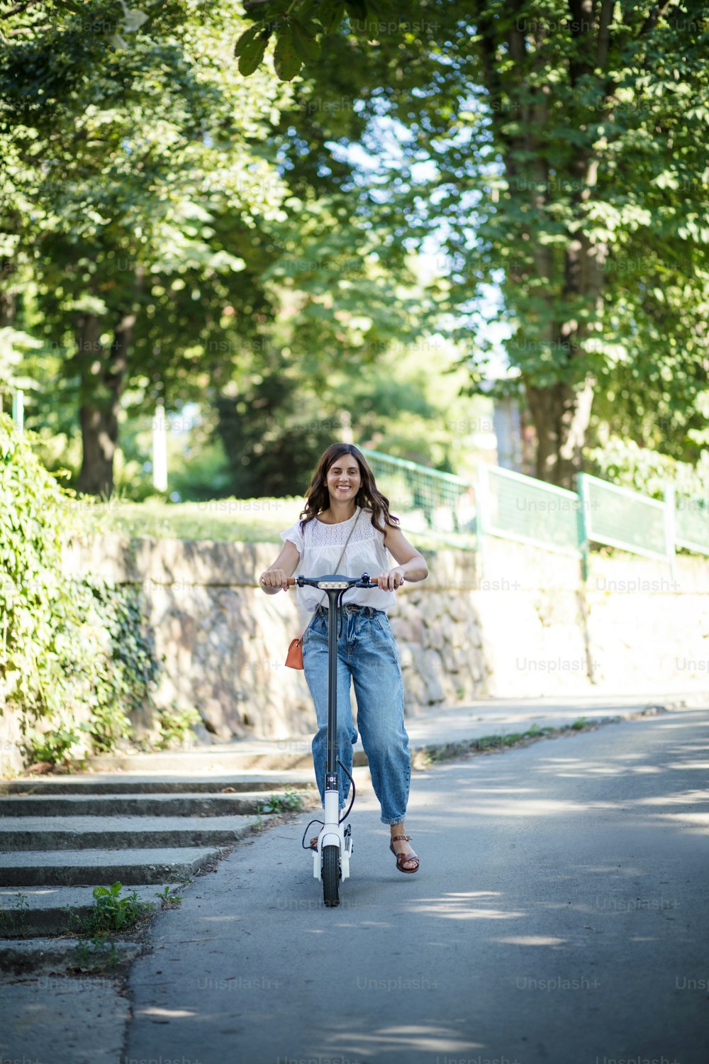 Woman riding scooter in nature.