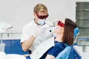 Retrato de primer plano de una paciente femenina que visita al dentista para blanquear los dientes en la clínica