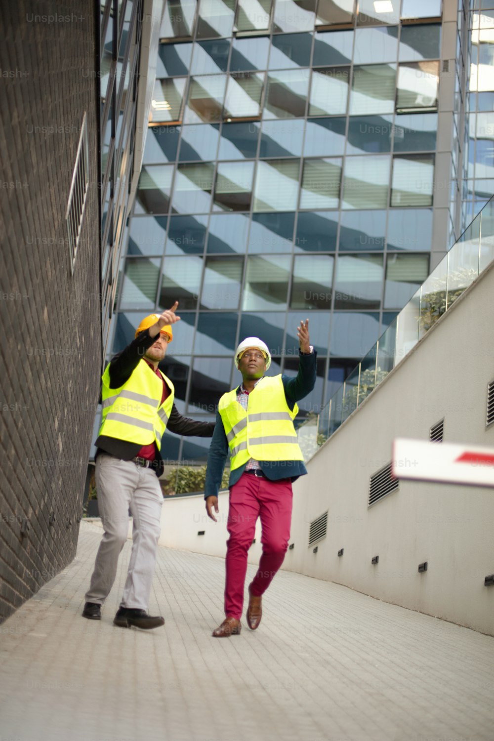 Engineer discussing the structure of the building with architects colleague at construction site.