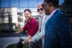 Three business man on street. Focus is on senior man.