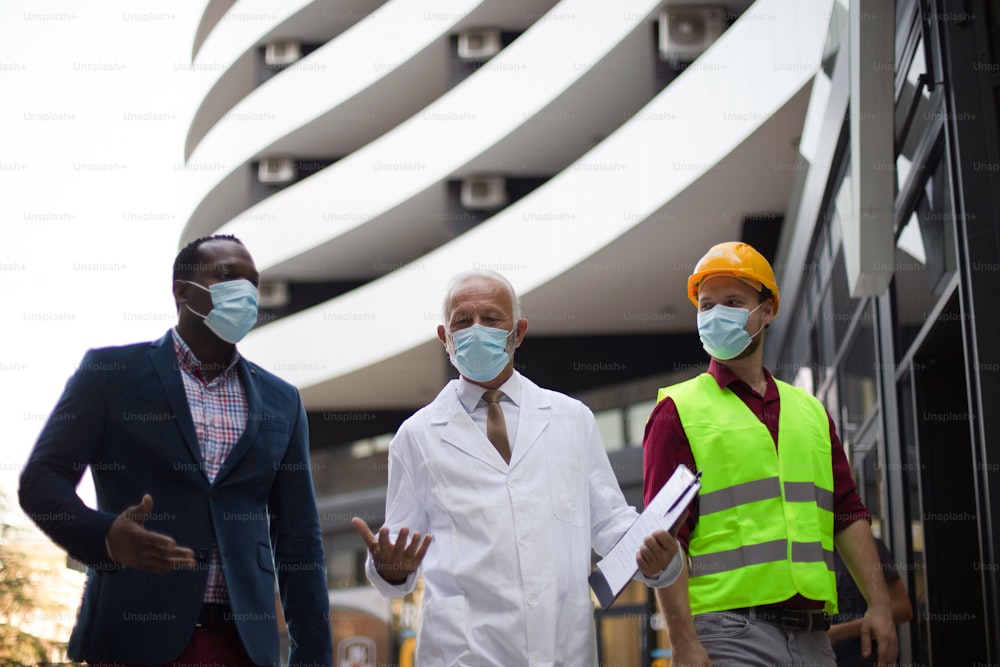 Uomo d'affari, medico e ingegnere che cammina per strada.