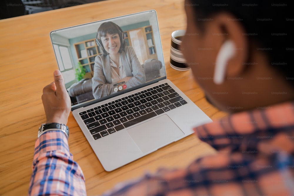 Portrait d’homme lors d’un appel vidéo au travail avec un ordinateur portable de la maison. Concept de bureau à domicile. Nouveau mode de vie normal.