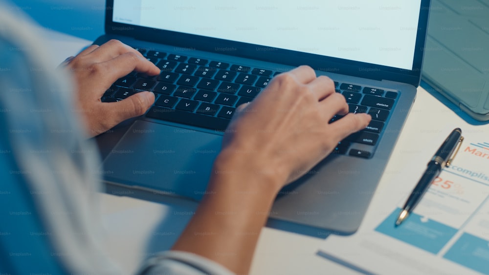 Freelance Asia lady using laptop hard work in living room at house. Working from home overload at night, remotely work, self isolation, social distancing, quarantine for corona virus prevention.