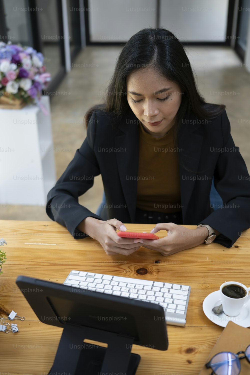 Asian businesswoman siting in office and using smart phone.