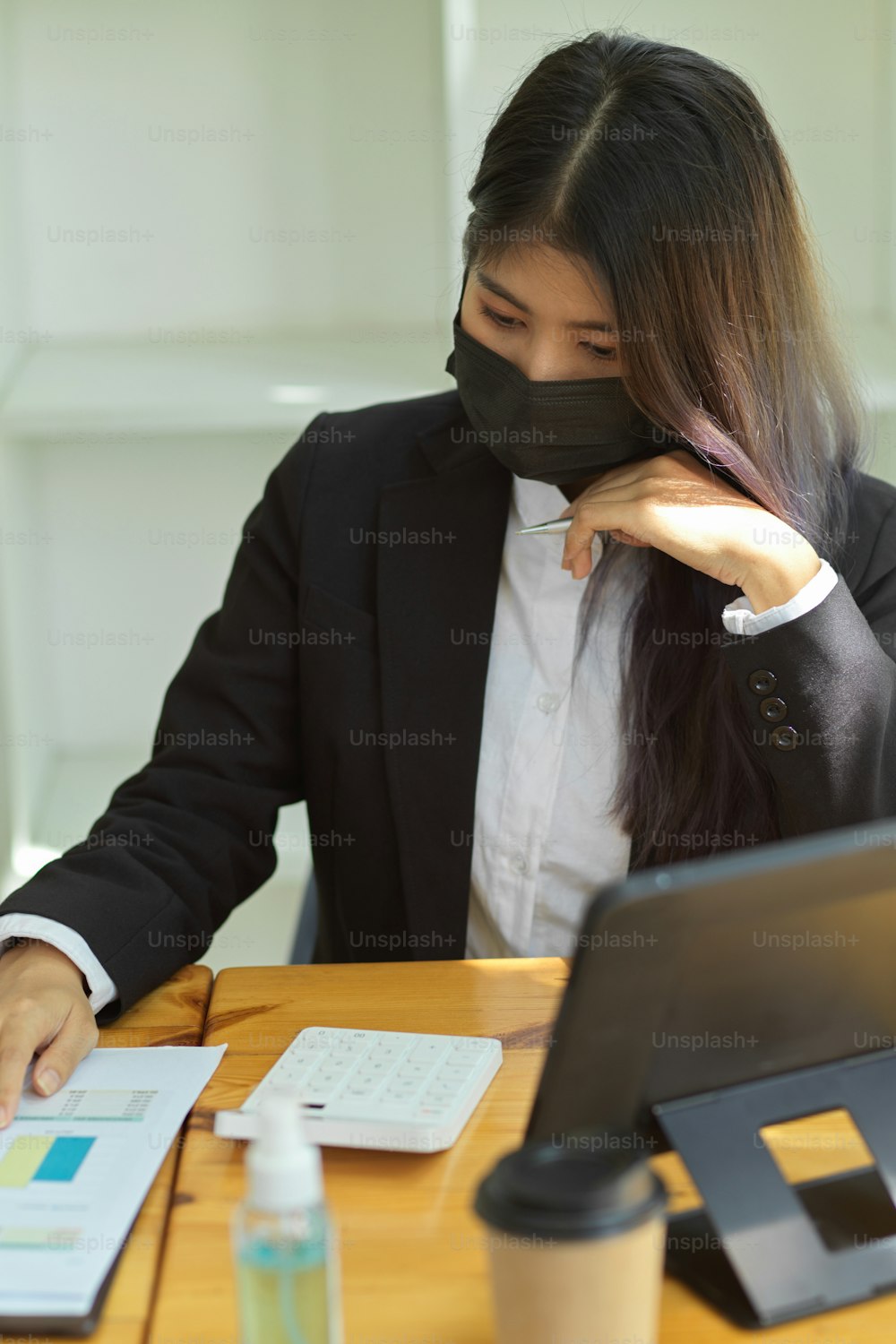 Foto recortada de empresários com máscara facial trabalhando com tablet digital e papelada no escritório