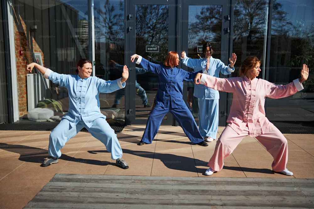 Mehrere Damen, die ihr Bestes geben, während sie die Philosophie des Qigong verstehen und Übungen machen