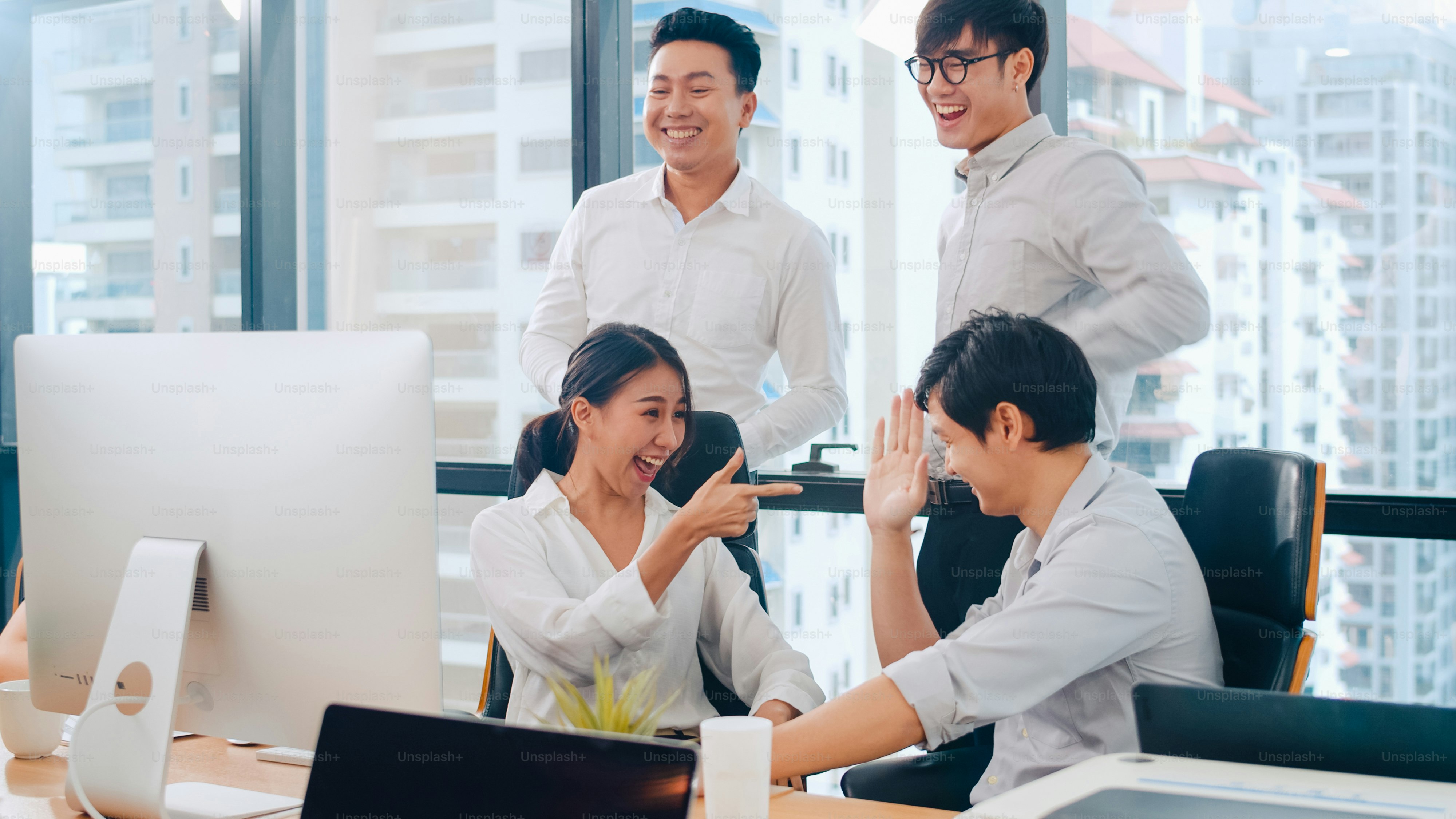 Kelompok pengusaha muda milenial Asia pengusaha dan pengusaha merayakan pemberian lima setelah berurusan merasa bahagia dan menandatangani kontrak atau perjanjian di ruang pertemuan di kantor modern kecil.