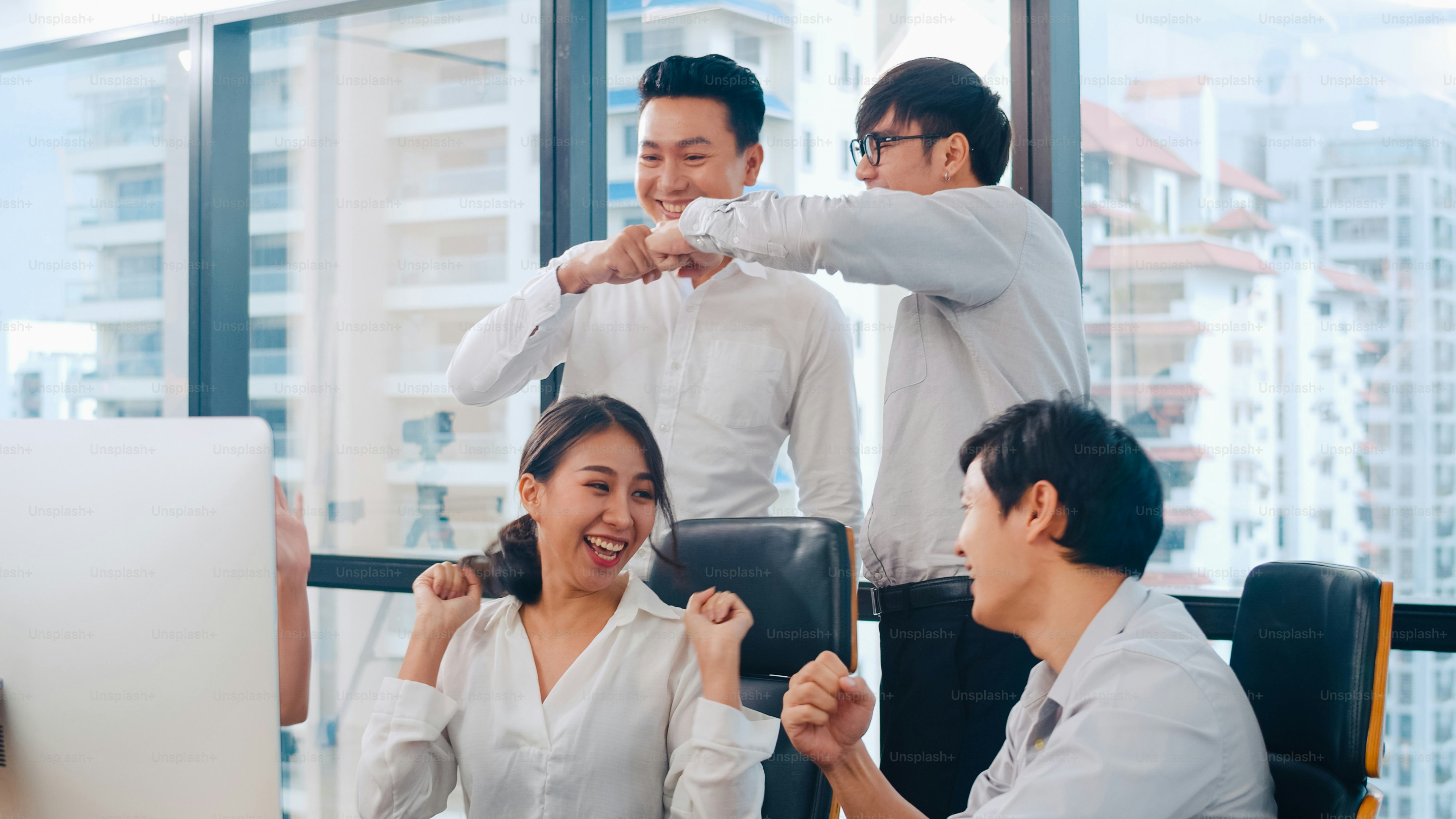 Millennial group of young businesspeople Asia businessman and businesswoman celebrate giving five after dealing feeling happy and signing contract or agreement at meeting room in small modern office.