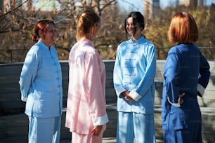 Mirthful ladies smiling while communicating with their qigong master outdoors
