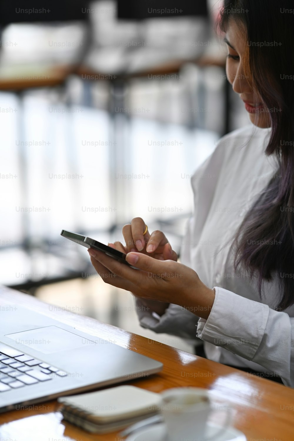Asian woman office worker sitting in office and using her mobile phone.
