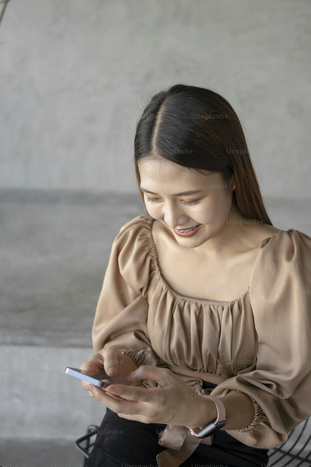 스마트폰을 사용하는 쾌활한 아시아 여성의 초상화.