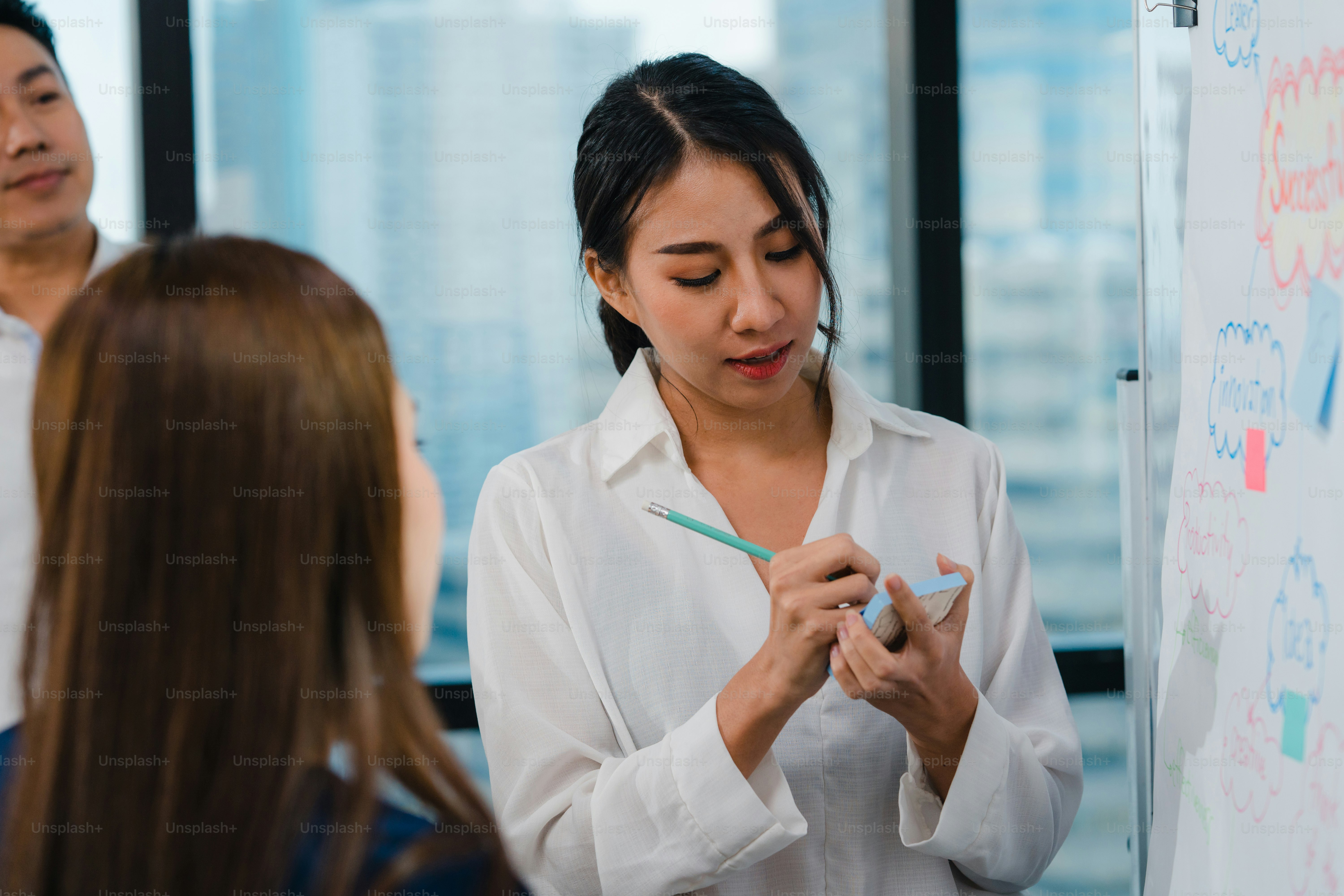 Les hommes et les femmes d’affaires asiatiques se réunissent pour réfléchir à des idées, mener des présentations d’affaires, des collègues de projet, travailler ensemble, planifier la stratégie de réussite, profiter du travail d’équipe dans un petit bureau moderne.