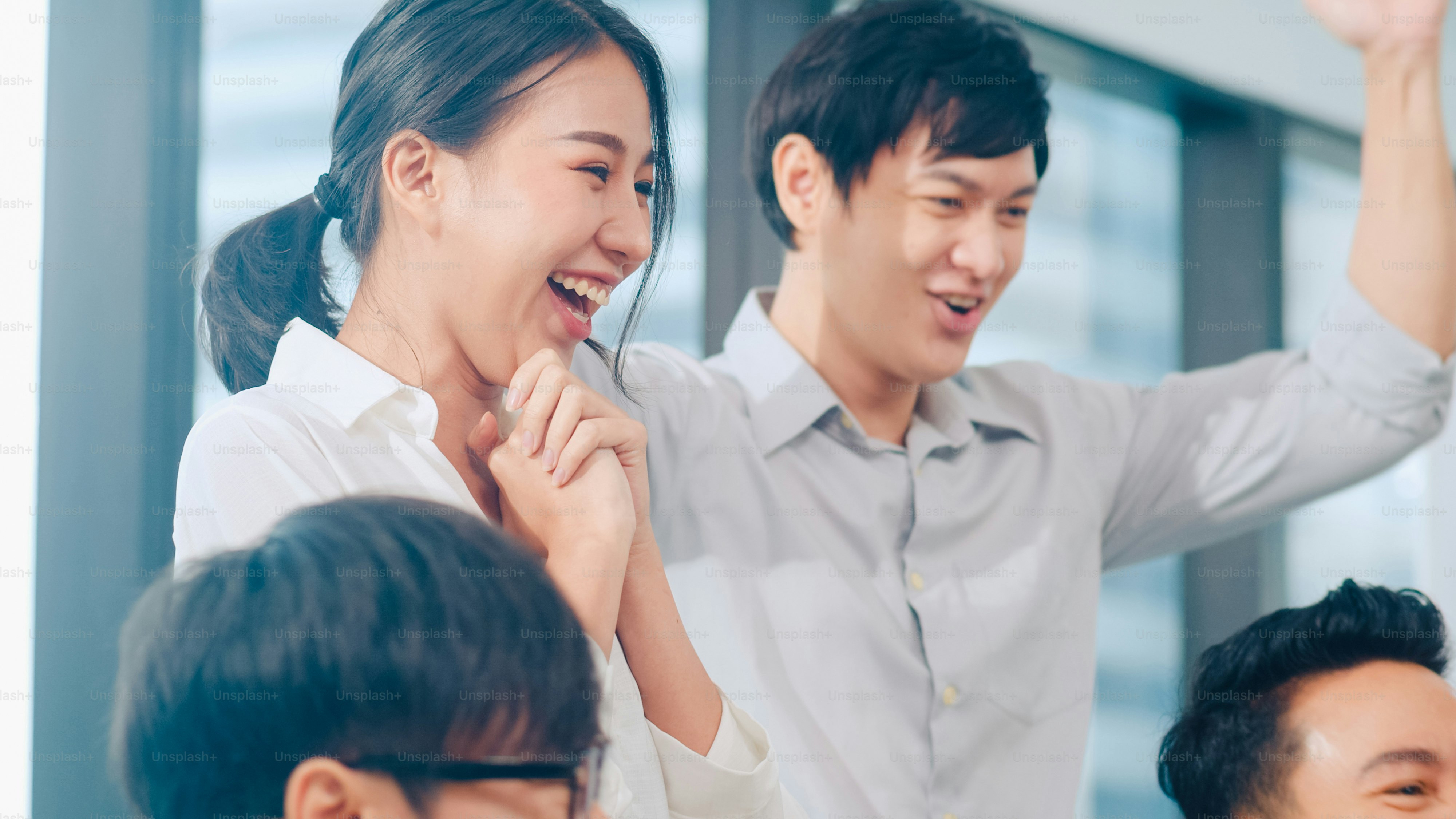 Kelompok pengusaha muda milenial Asia pengusaha dan pengusaha merayakan pemberian lima setelah berurusan merasa bahagia dan menandatangani kontrak atau perjanjian di ruang pertemuan di kantor modern kecil.