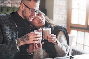 Cute multiracial couple sitting together in cafe. Asian girl with her caucasian boyfriend.