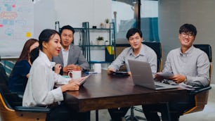 밀레니엄 세대 아시아 사업가와 사업가들은 전화 회의 화상 회의를 통해 함께 일하는 새로운 프로젝트 동료에 대한 아이디어를 브레인스토밍하고 전략을 계획하며 현대적인 사무실에서 팀워크를 즐깁니다.