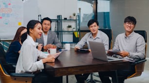 Los hombres y mujeres de negocios de la generación del milenio de Asia, que tienen una conferencia por videollamada, una reunión, una lluvia de ideas sobre nuevos proyectos, colegas que trabajan juntos, planifican la estrategia, disfrutan del trabajo en equipo en una oficina moderna.